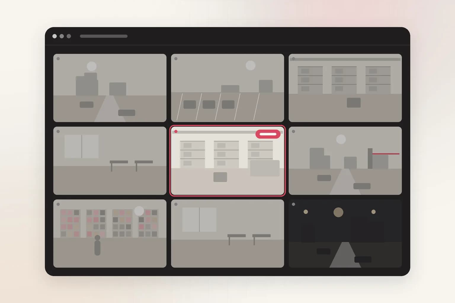 A dark video management wall of 9 camera feeds, with a coral alert badge on one camera.